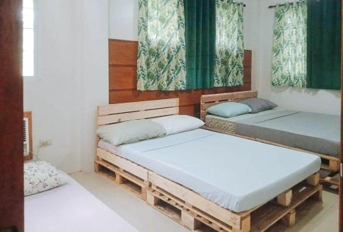 BawaRedDoorz @ Balai Baibai Cagayan的绿窗帘间内的两张床