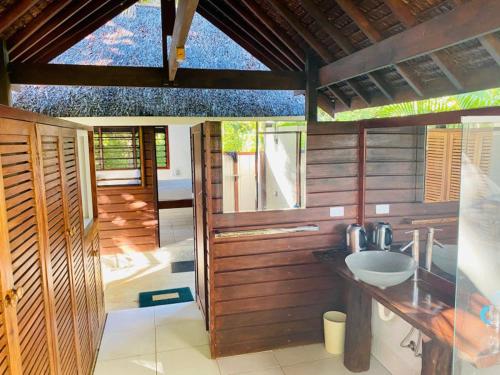 卢甘维尔Freshwater Private Resort的木墙客房内设有带水槽的浴室