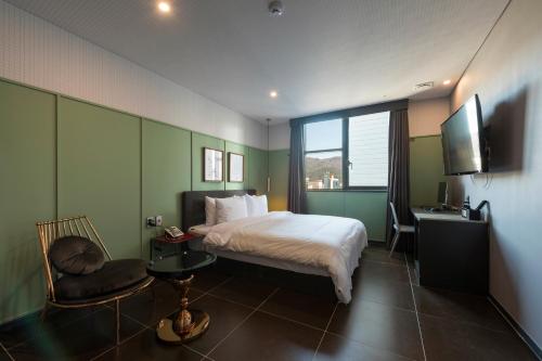 釜山Browndot hotel Guseo的一间卧室配有一张床、一张书桌和一台电视