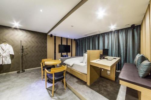议政府市Jbis Hotel的酒店客房配有一张床铺、一张桌子和一张书桌。