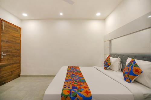 诺伊达FabExpress F9 Noida Sector 27的一间卧室配有一张带彩色毯子的床