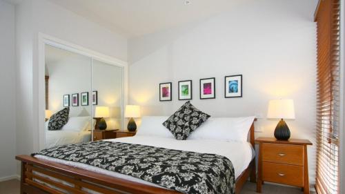 阿波罗湾雷恩度假屋的一间卧室配有一张床和镜子