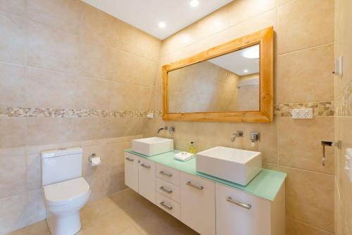 阿波罗湾最美瑞度假屋的一间带卫生间、水槽和镜子的浴室