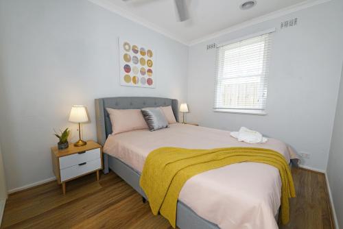 帕克德尔Pet-friendly Bayside 4BR Rental House near Mentone的一间卧室配有一张黄色毯子床