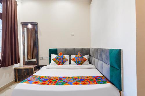 瓜廖尔FabExpress Royal Villas的一间卧室配有一张带色彩缤纷枕头的大床