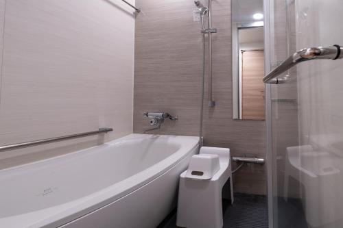 广岛Hotel Vista Hiroshima的白色的浴室设有浴缸和卫生间。