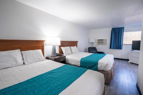 肯纳威克Kennewick Inn & Suites Tri Cities的酒店客房设有两张床和电视。