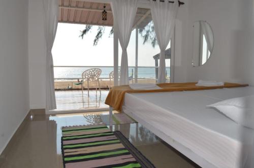 卡纳科纳Baywatch Beach Resort patnem的一间卧室配有一张床,享有海景