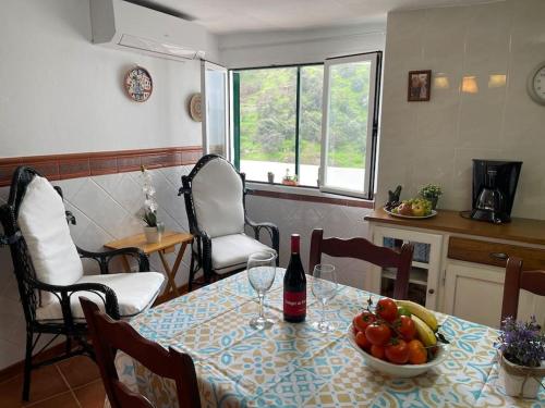伊斯坦Casa Rural Manantial de las Jaras的一张桌子,上面放着一碗水果和一瓶葡萄酒