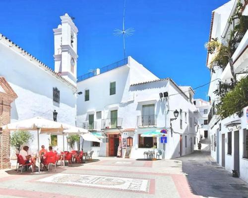 伊斯坦Casa Rural Manantial de las Jaras的一条有白色建筑的街道,人们坐在桌子上