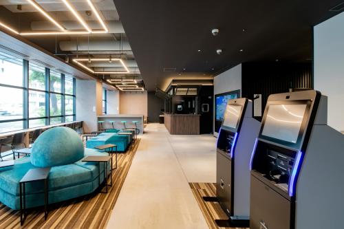 那霸Prince Smart Inn Naha的办公室设有配备蓝色椅子和电视的等候室