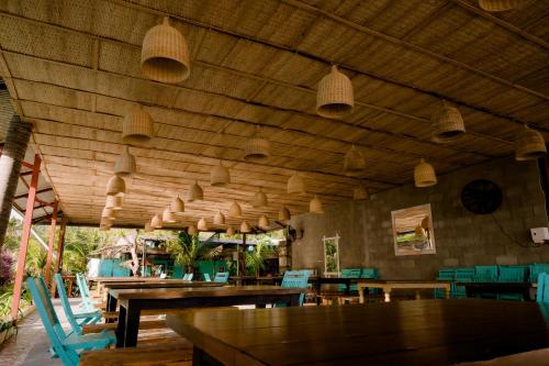 罗夷Coco Beachcamp La Gi的餐厅设有木制天花板和桌椅