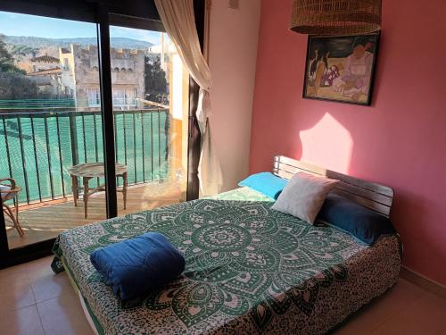 帕拉莫斯2 Bonita habitación con balcón的一间卧室配有一张带蓝色枕头的床和一个阳台