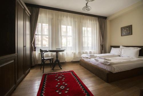 克鲁舍沃Casa La Kola Krusevo的一间卧室配有一张床、一张桌子和一个窗户。