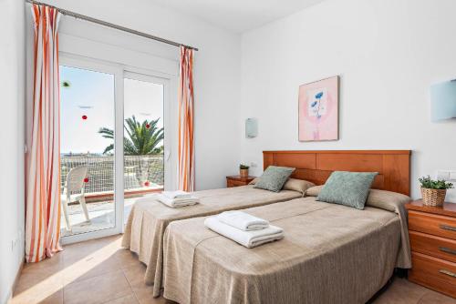 卡兰博希Villas Calan Bosch Emily的一间卧室配有一张床,上面有两条毛巾