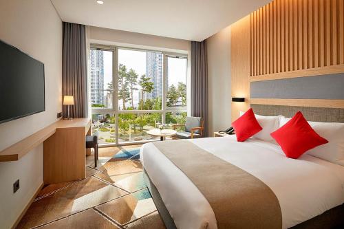 华城市Staz Hotel Premier Dongtan的酒店客房配有一张带红色枕头的大床