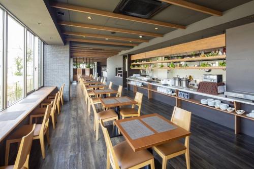 福冈Hotel Grand View Fukuoka-Kuko的一间带木桌椅的餐厅和一间厨房