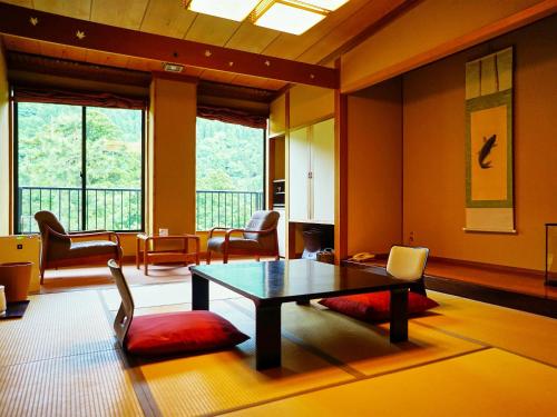 砺波市三乐园日式旅馆的客厅配有桌椅和窗户。