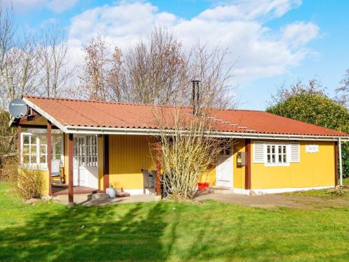 诺德堡4 person holiday home in Nordborg的黄色的房屋,有红色的屋顶