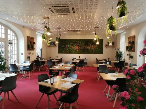 热莫扎克金狮餐厅酒店的一间带桌椅和鲜花的餐厅