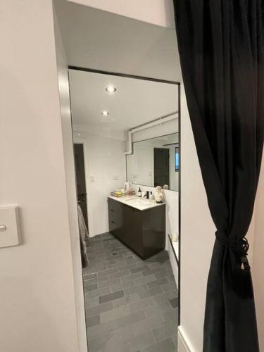 悉尼The mini New-Yorker的一间带大镜子和盥洗盆的浴室