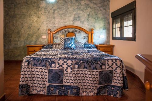 Poveda de la SierraHospedaje Rural Casa Parri的一间卧室配有一张带蓝色和白色床单的床。