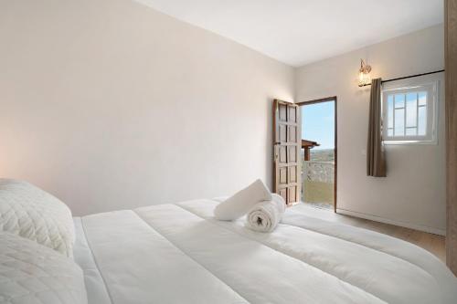 FasniaFinca Lucrecia的白色的卧室设有一张大床和一个窗户