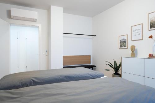 格拉茨MH Living - 39 - Scandinavian Living Dream in Center的一间白色卧室,配有一张床和一个梳妆台