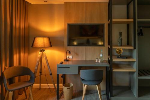 维梅河畔罗滕堡Hotel fine art的客房设有带台灯的书桌和桌椅
