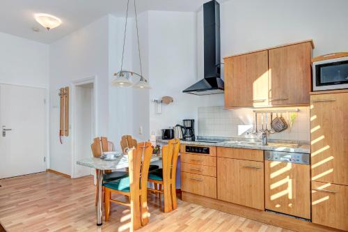 赛巴特班森Villa Frieda Wohnung 6的厨房配有木制橱柜和桌椅