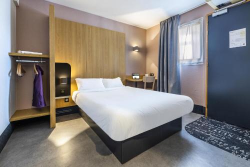 佩皮尼昂B&B HOTEL Perpignan Sud Porte d'Espagne的一间设有大床和窗户的酒店客房