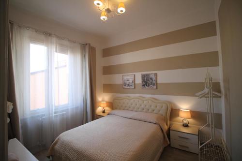 比萨Secondopiano的一间卧室配有一张床和条纹墙