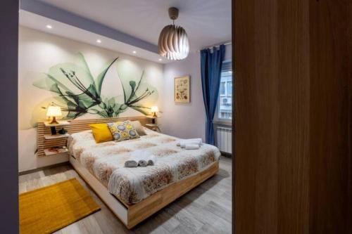圣贝内代托-德尔特龙托Casa Gabry Design a due passi dal centro e dal mare的卧室配有一张大床,墙上挂着植物