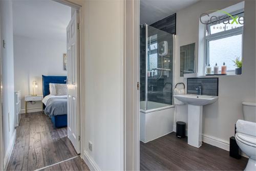 达德利3 Bedroom Luxe Living for Contractors and Families by Coraxe Short Stays的一间带水槽和卫生间的浴室以及一张床