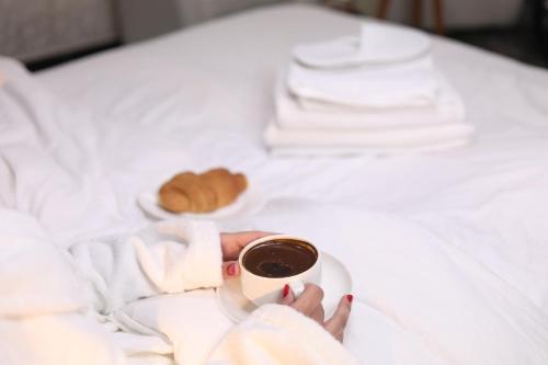 安曼The Castle Hotel的把咖啡藏在床上的妇女