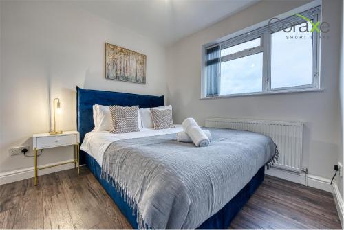 达德利3 Bedroom Luxe Living for Contractors and Families by Coraxe Short Stays的一间卧室配有一张蓝色的床和窗户