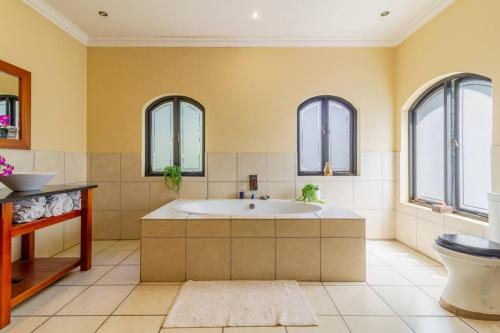 约翰内斯堡Lovely Family home in Bryanston的带浴缸和卫生间的浴室以及窗户。