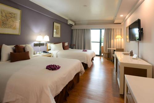 塔穆宁Days Inn Guam - Tamuning的酒店客房设有两张床和电视。