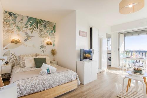 卡布尔Appartement cosy avec vue imprenable sur Cabourg - accès direct plage - proche centre ville的一间卧室配有一张床,墙上配有电视