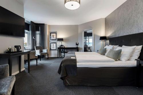 兰讷斯康优兰贝斯特韦斯特普拉斯酒店的酒店客房设有一张大床和一张书桌。