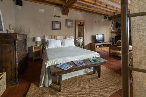 纳瓦夫里亚Posada Real Mingaseda的一间卧室配有一张带桌子和一台电视的床。