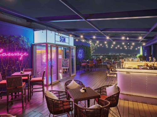 胡志明市西贡机场宜必思酒店的一间带桌椅的餐厅和一间酒吧