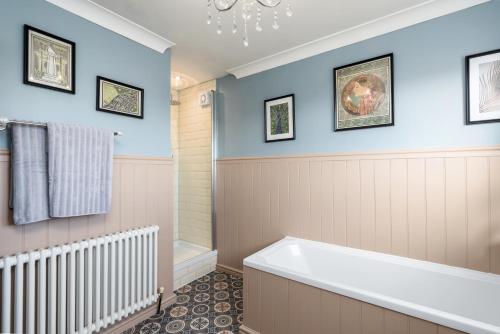 唐克斯特The Laurel Cottage的浴室配有蓝色的墙壁和浴缸。