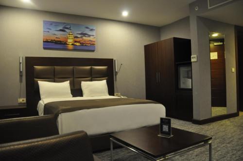 科贾埃利Happy Inn Gebze Hotel的酒店客房设有一张大床和一张桌子。