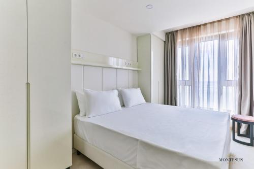 布德瓦Montesun RAF Apartments的白色的卧室设有一张大床和一个窗户