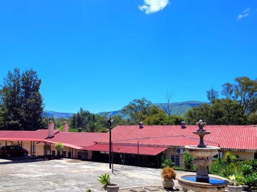 巴德普拉斯Mumo Resort的一座红色屋顶建筑前的喷泉