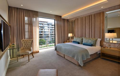 约翰内斯堡The Houghton Hotel, Spa, Wellness & Golf的一间卧室设有一张大床和一个大窗户