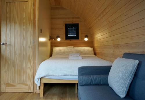 什鲁斯伯里Habberley Glamping Pods的木制客房内的一间卧室,配有一张床