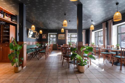 派克波特斯耐兹库克罗克斯酒店的餐厅设有木桌和椅子,种有植物