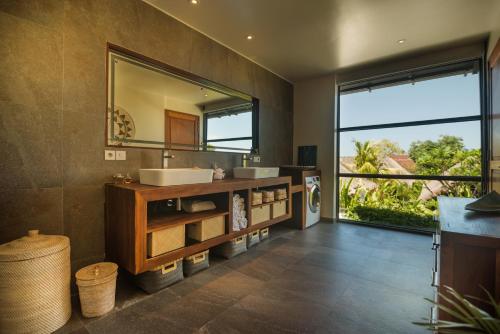 沙努尔Karmagali Suites Adults only & Private Pool Family Villas的一间带两个盥洗盆和大镜子的浴室
